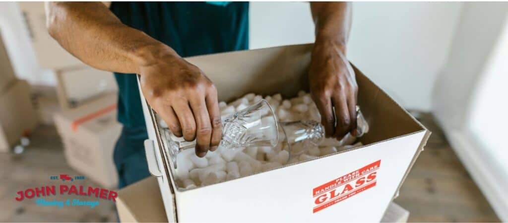 A hand of a guy placing glasses in the box